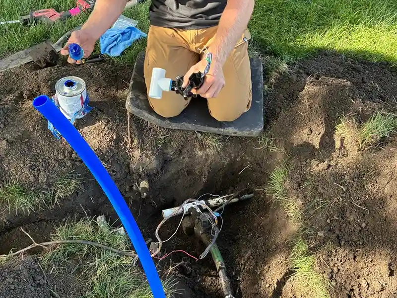 Worker installing new irrigation piping